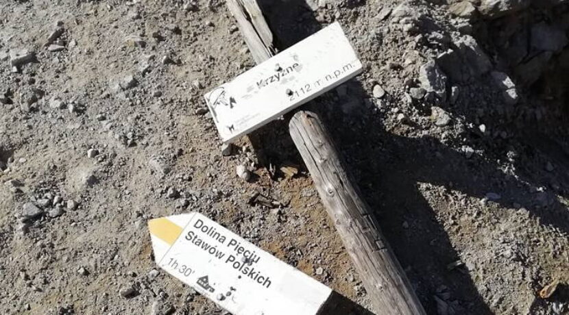 Zniszczona tabliczka na przełęczy Krzyżne